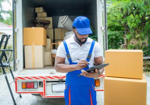 Moving company employee checks boxes in a small truck before sending them to the homeowner.